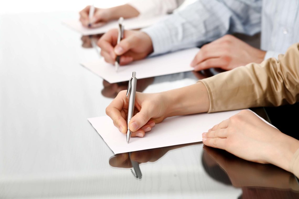 Row of writing human hands